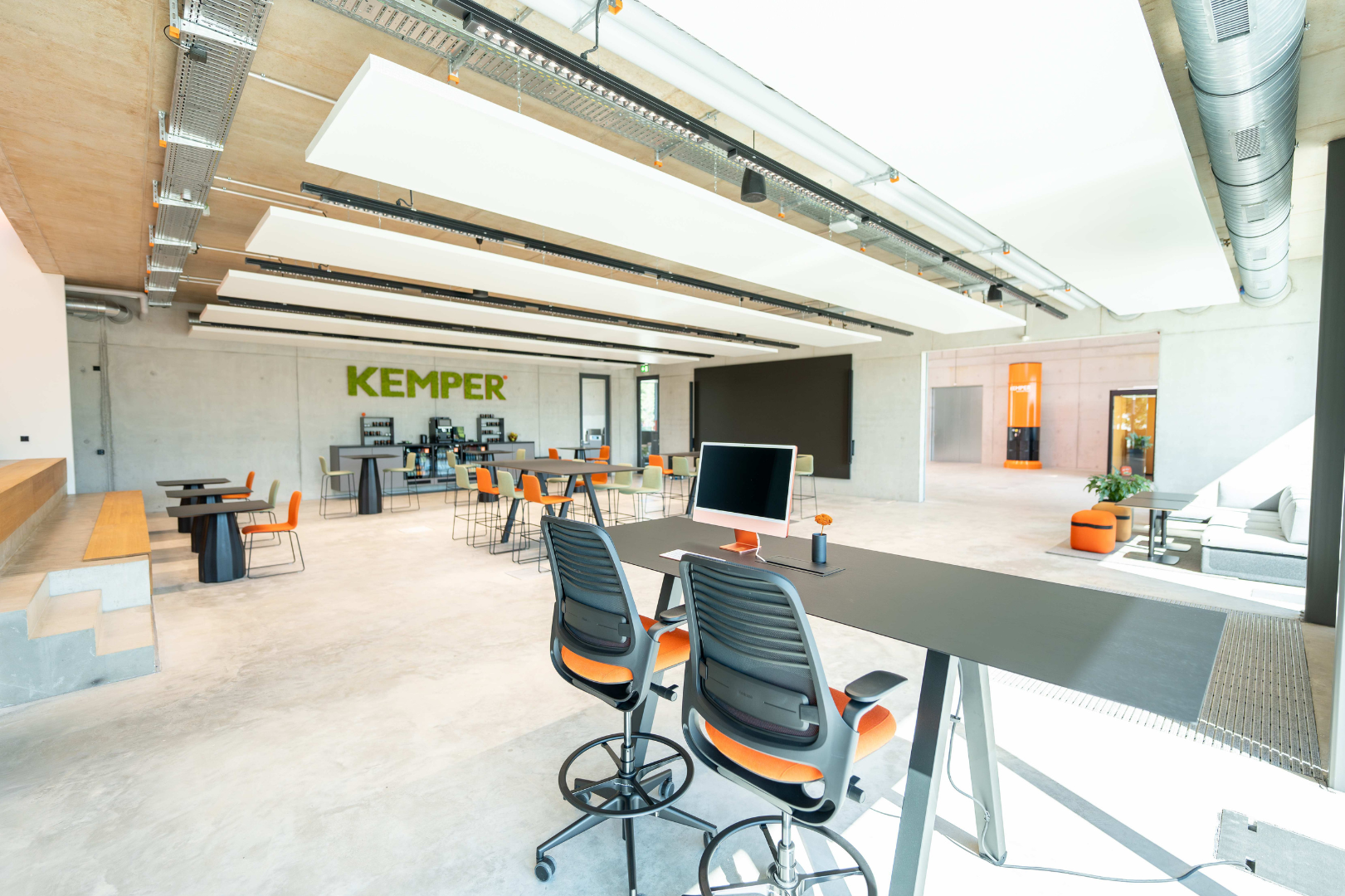 Großer, moderner Arbeits- und Aufenthaltsbereich mit Arbeitsplätzen, Sitzgelegenheiten und Meetingzonen im KEMPER Headquarter